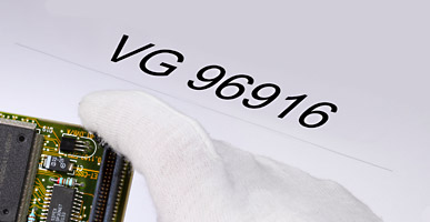 Auf einem Dokument steht VG 96916 geschrieben, darüber ist der Ausschnitt einer Elektronikplatine zu sehen.