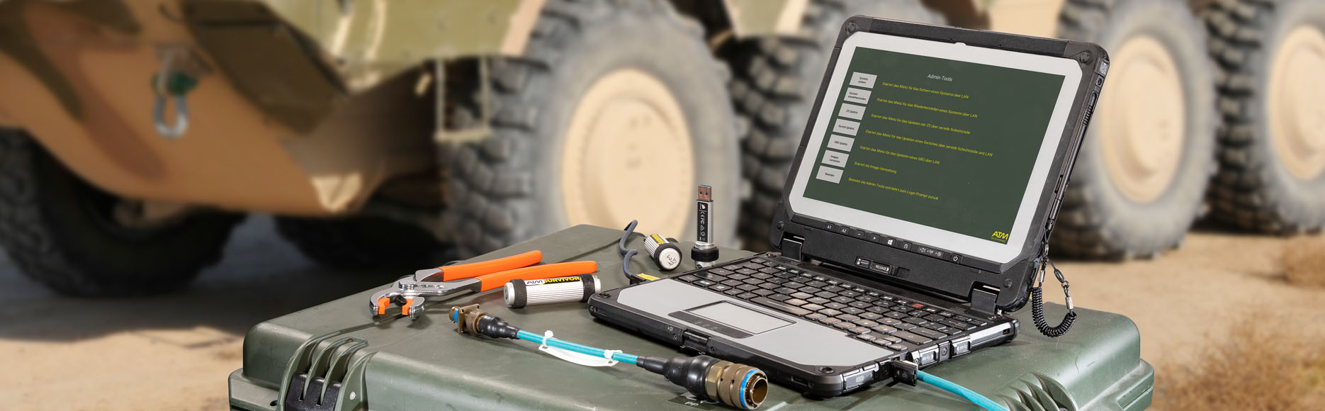 Laptop, Kabel und Werkzeug mit BOXER im Hintergrund