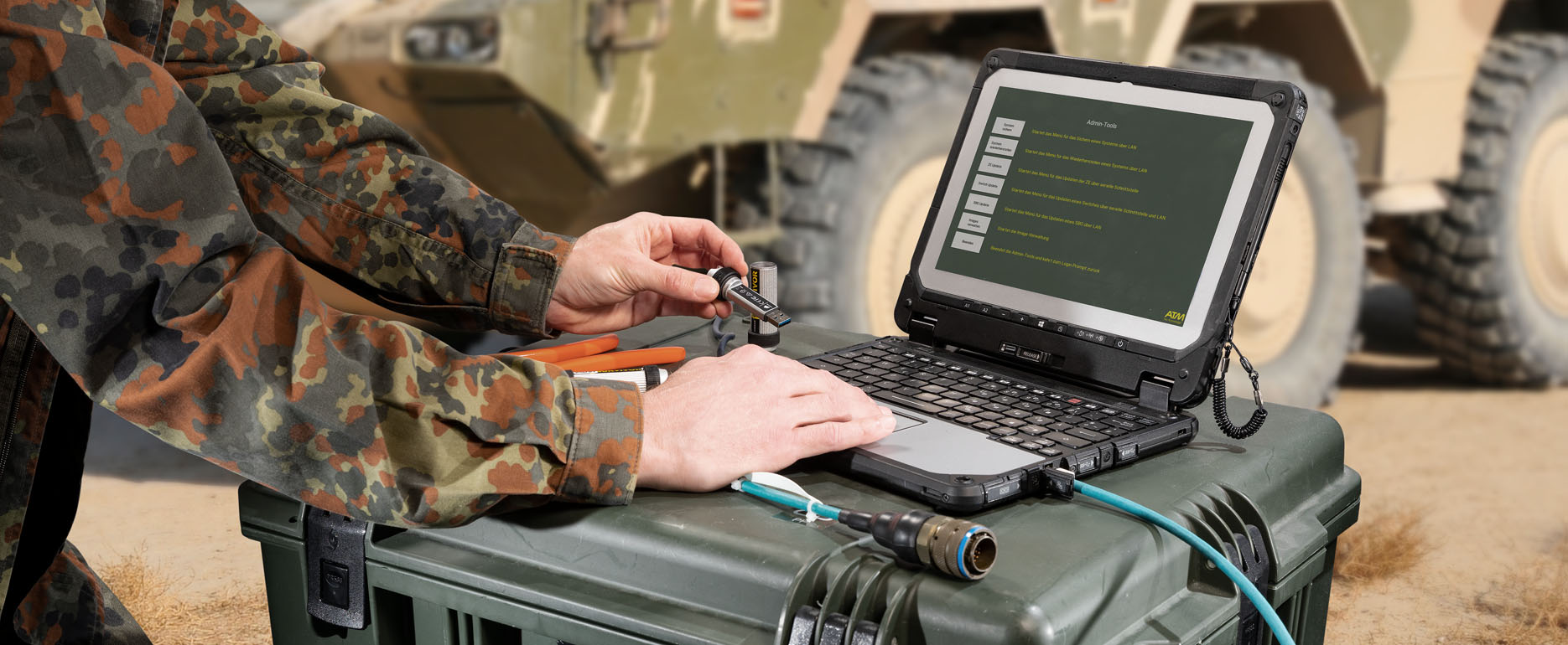 Soldier inserting a USB stick into a laptop