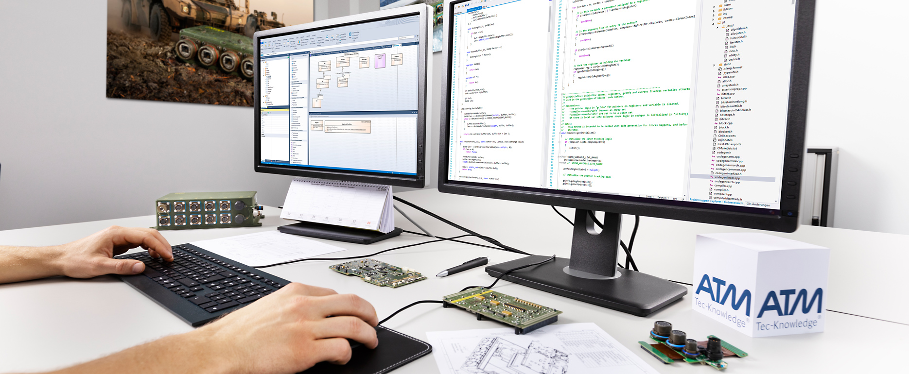 Ein Entwickler sitzt am Schreibtisch, die Hände auf der Tastatur, auf dem Bildschirm sind Programmcodezeilen zu sehen